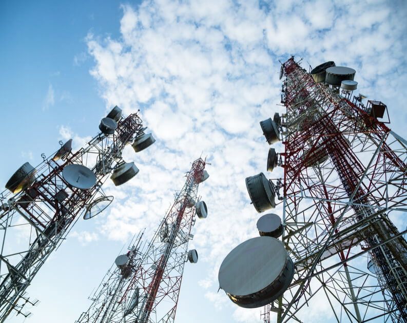 Telecommunication towers with antennas and microwave dishes against the sky